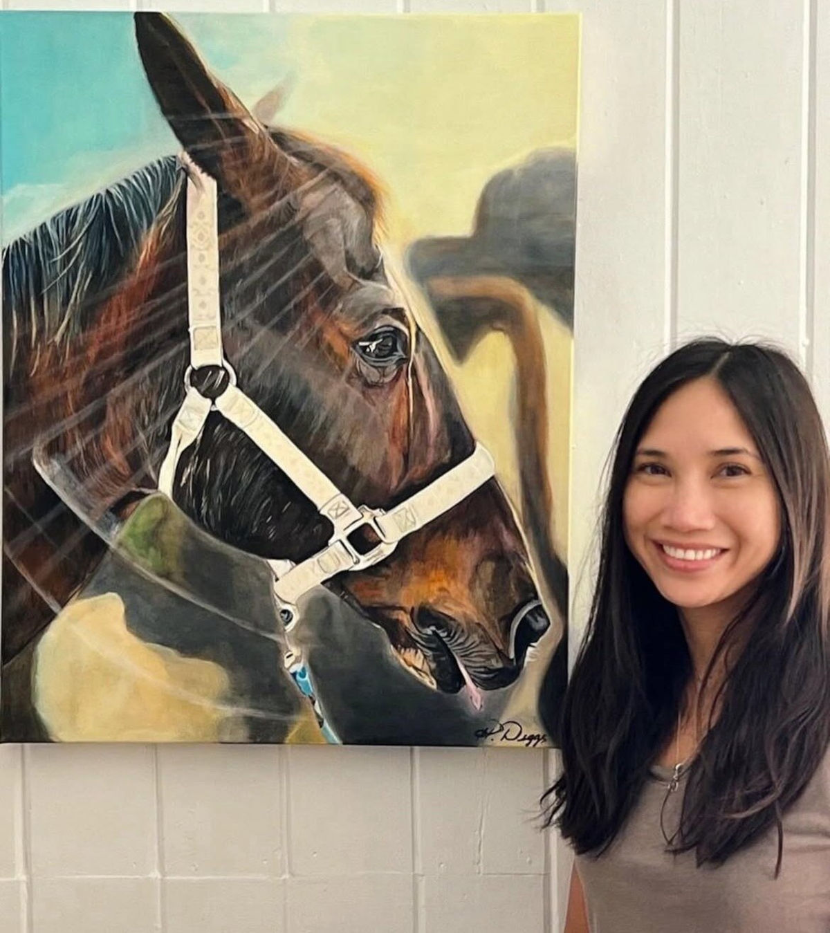 artist Heather Diggs next to a painting of a horse