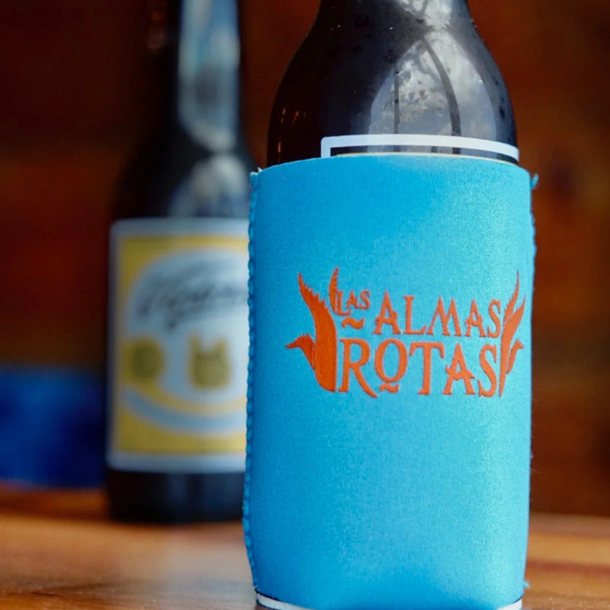 A bottle with a blue Las Almas Rotas sleeve