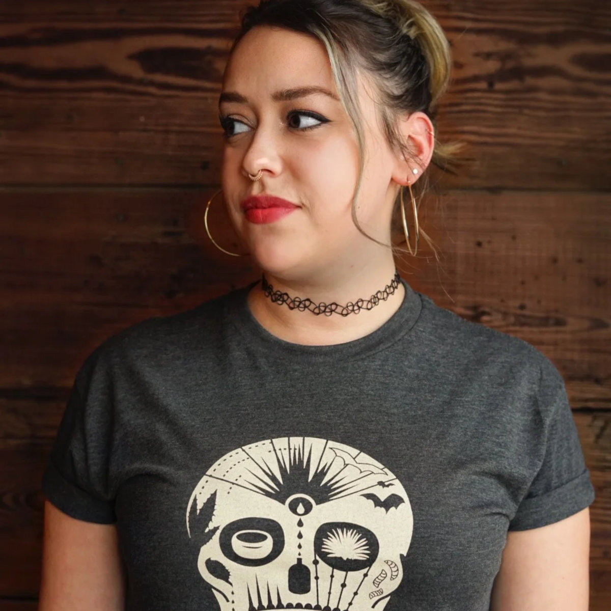 A girl is wearing a t-shirt with a skull print.