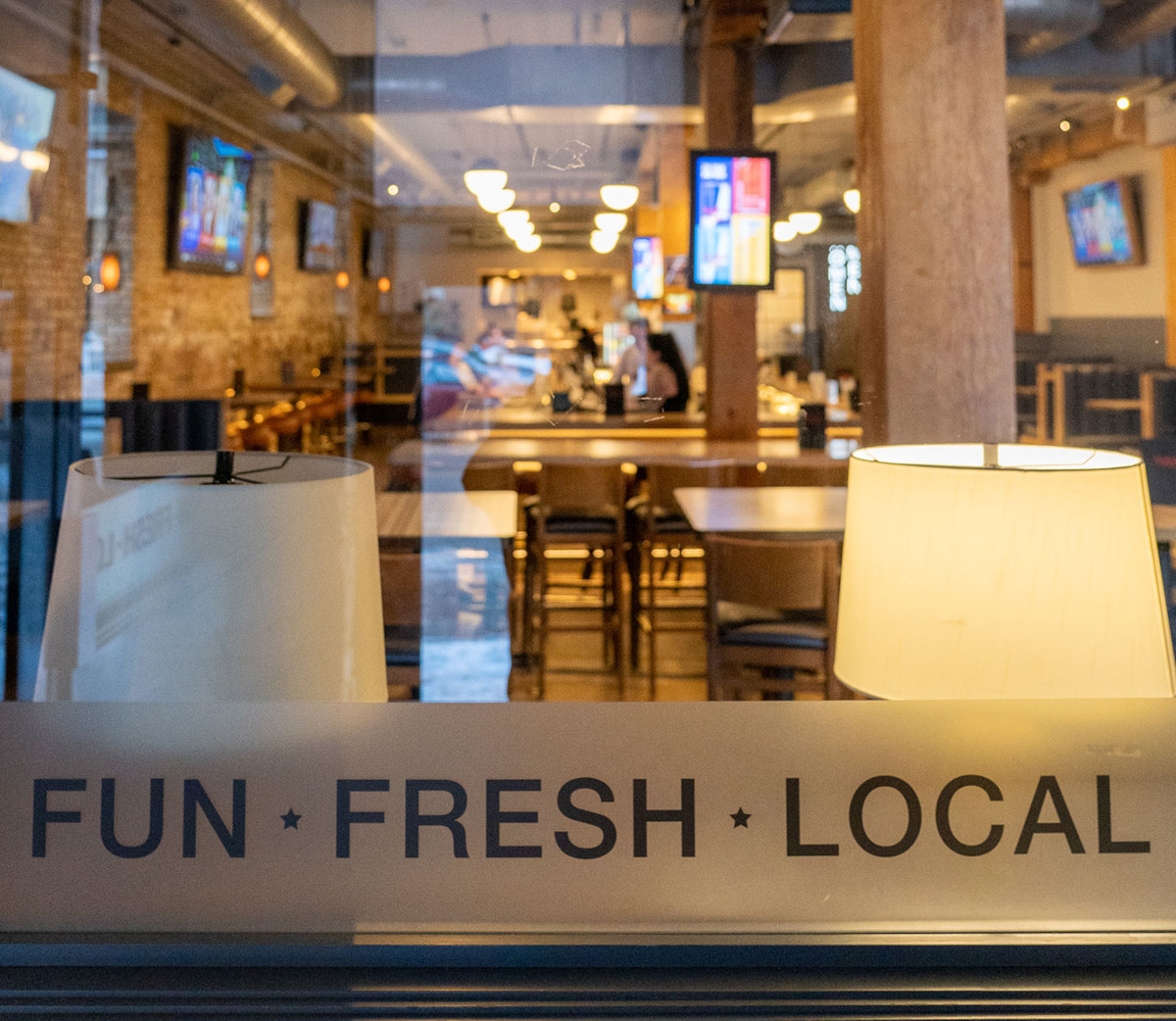 View of a restaurant interior with lamps, tables, and a bar area