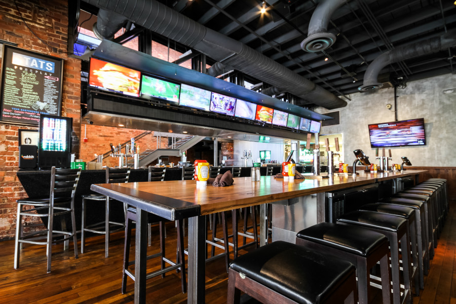 Restaurant interior, high chairs table, bar area in the back