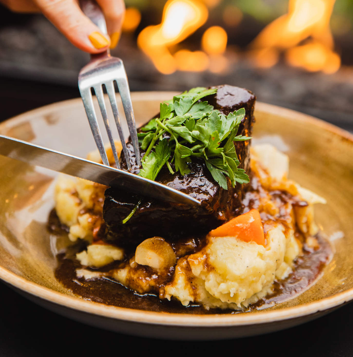 Tender braised short rib served over a bed of creamy mashed potatoes.