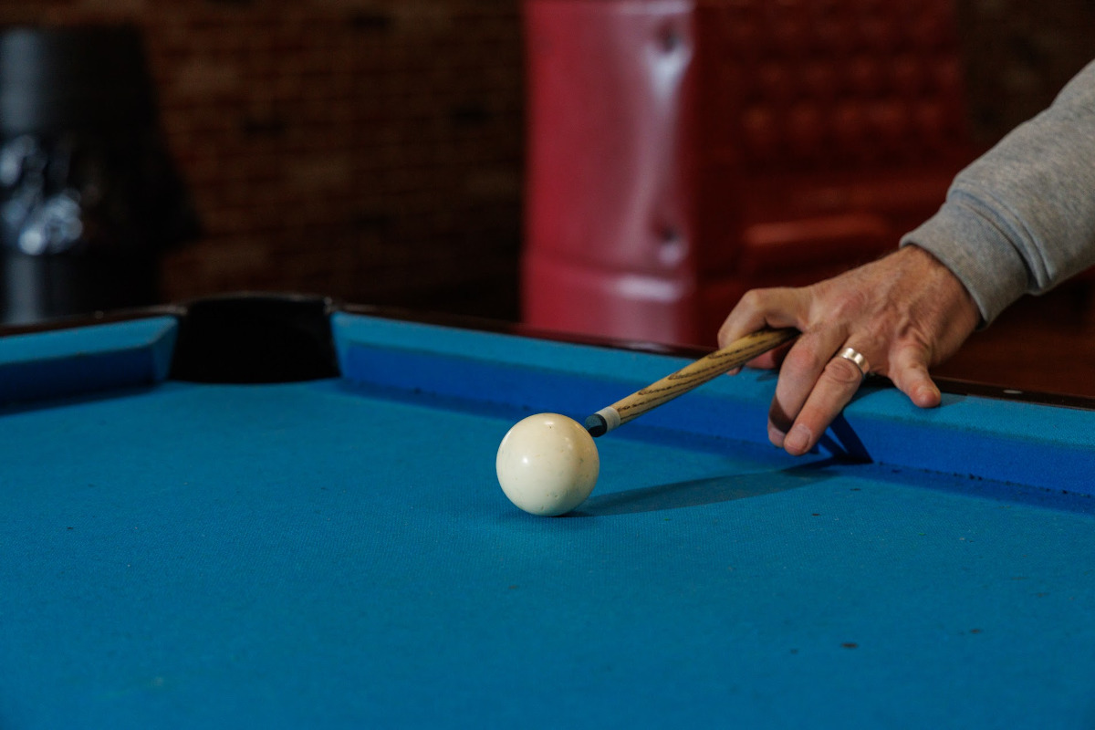 Close-up of person aiming to hit a billiards ball