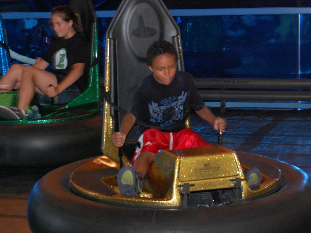An excited kid driving a bumper car