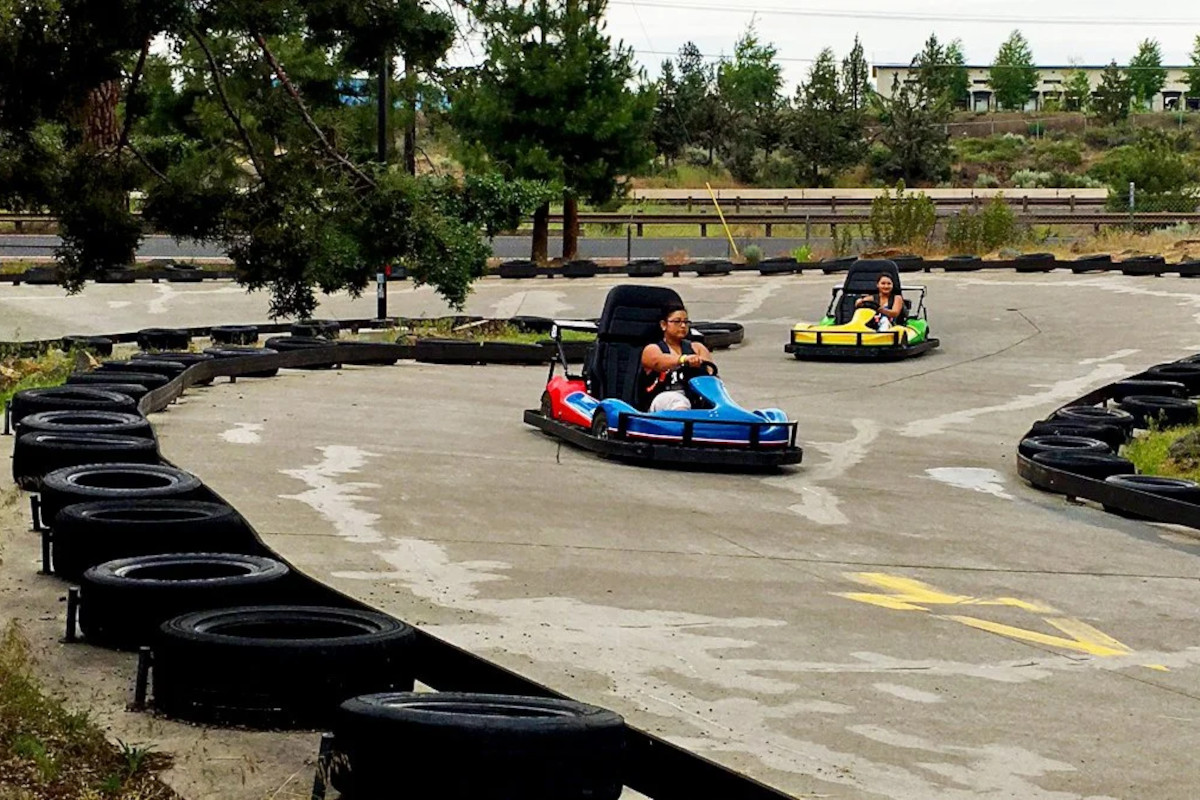 People kart racing at the track