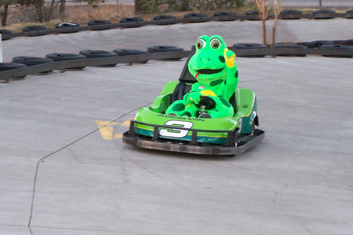 A costumed mascot driving a cart