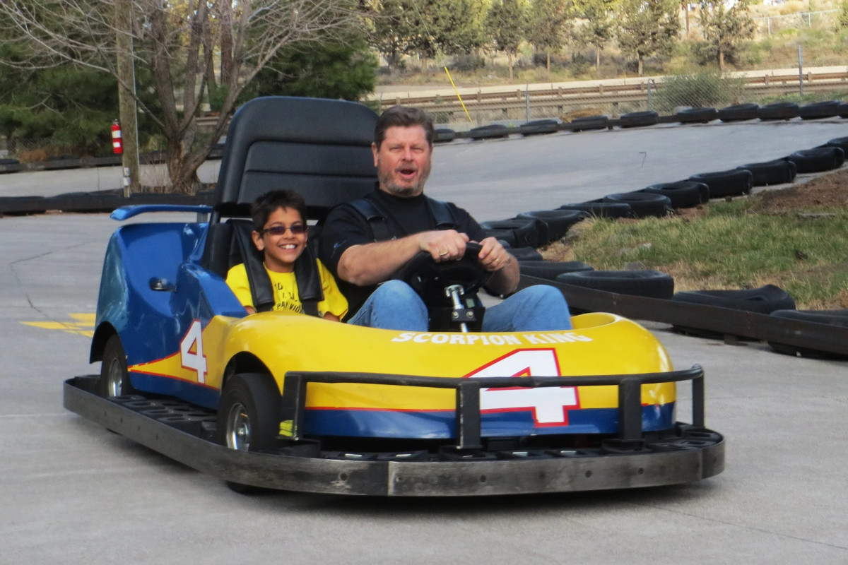 A grown-up and a kid in a go-kart