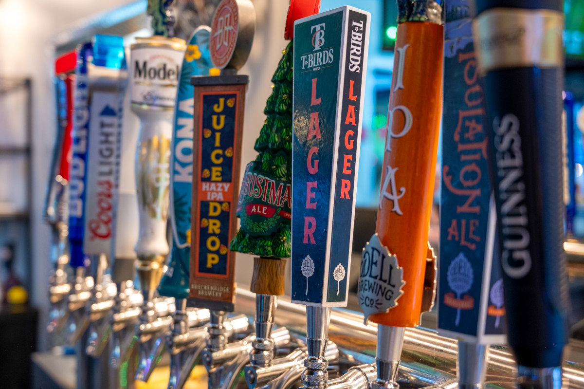 Beer tap handles for various beers in a bar