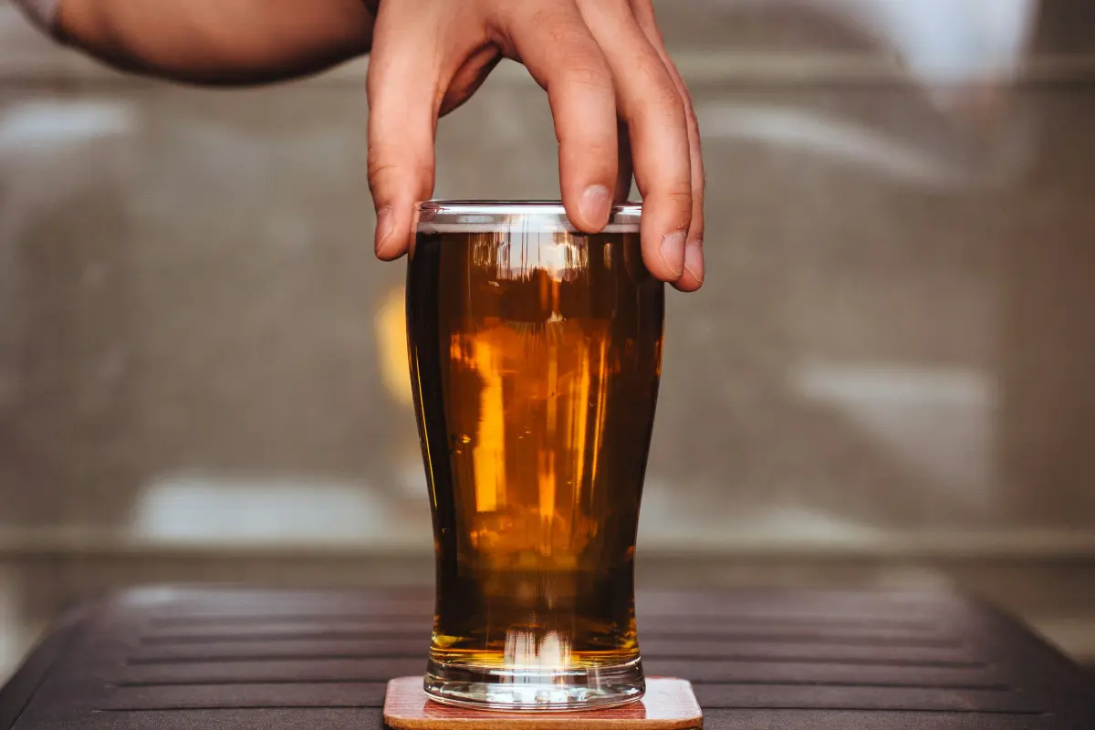 Hand touching a glass of beverage 