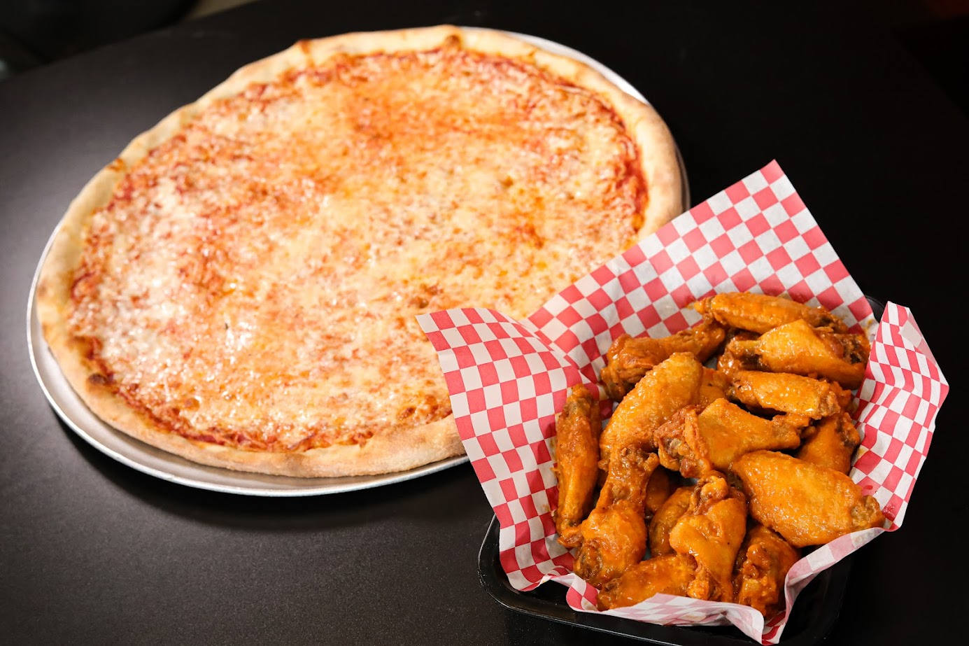 pizza and wings arranged on a table.