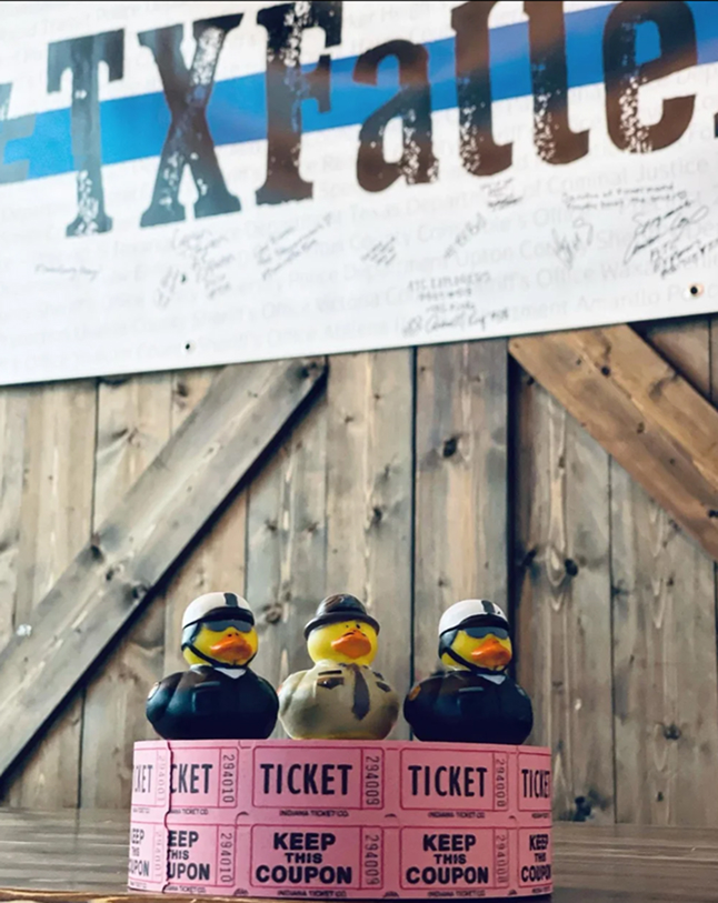 Signed TXFallenPD banner with rubber duck raffle tickets