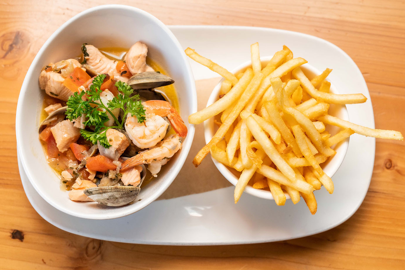 Seafood dish with a side of fries.