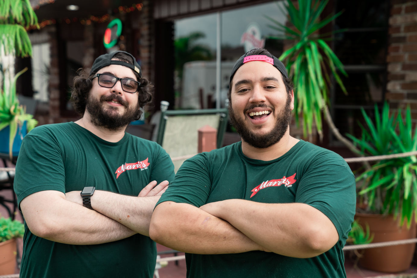 Two staff members posing for a photo outside