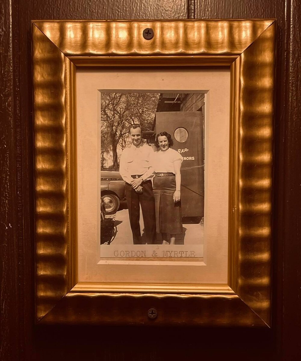 An old photo of a man and woman standing in front of a door.