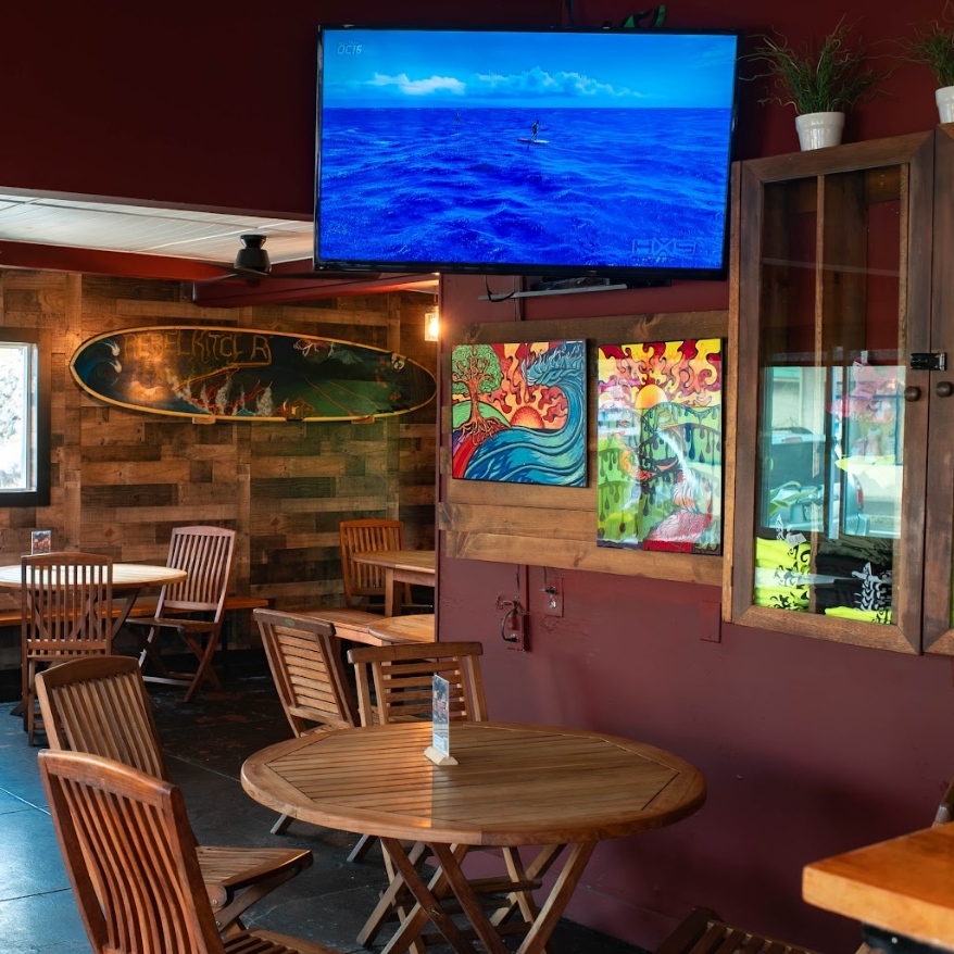 Rebel Kitchen dining room with surfboard art and TV