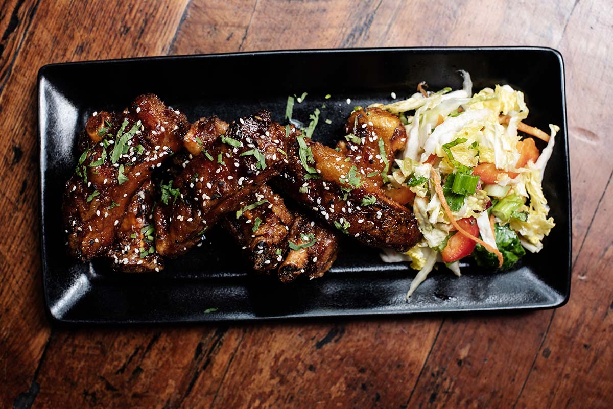 Marinated ribs with herbs and sesame seeds on top and a side salad