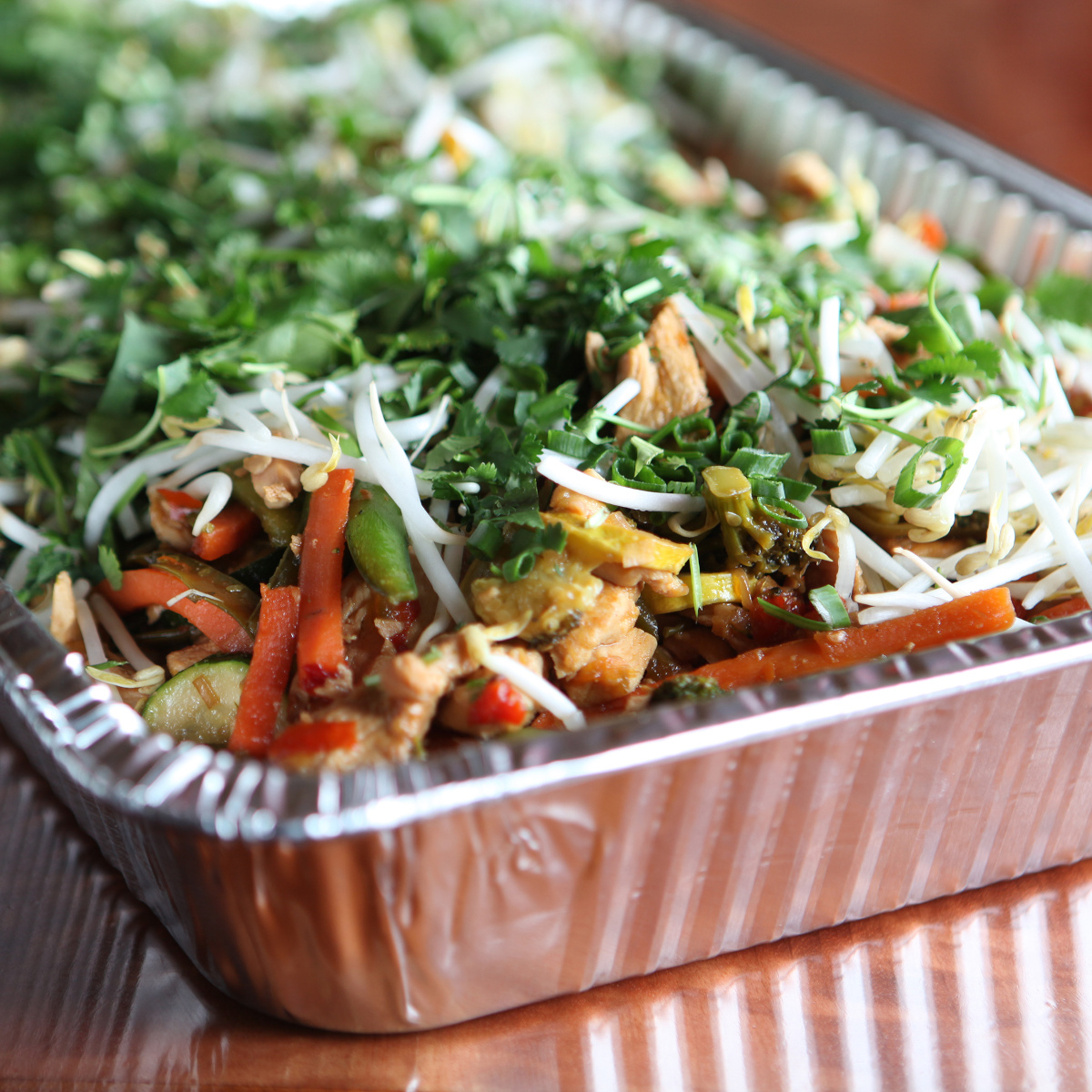 A serving tray displaying a variety of colorful vegetables alongside pieces of meat.