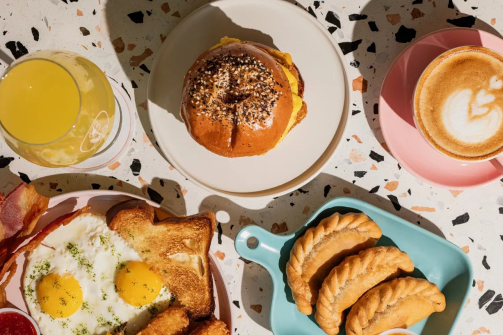 a plate of food with eggs and burgers and juice and coffee