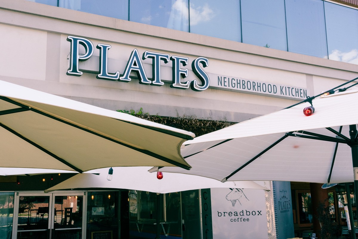 A restaurant with white umbrellas in front of it.