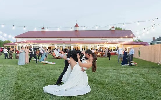 Bride and a Groom kissing in fromt of guests in the big yard