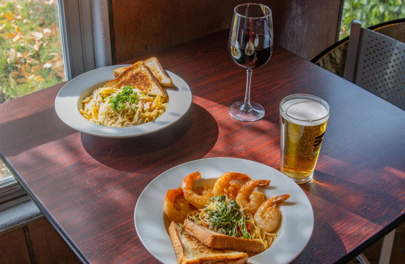Pasta dish plate and Shrimp Scampi plate served with wine and beer