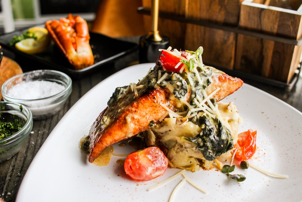 Grilled salmon with spinach cream sauce and roasted cherry tomatoes.