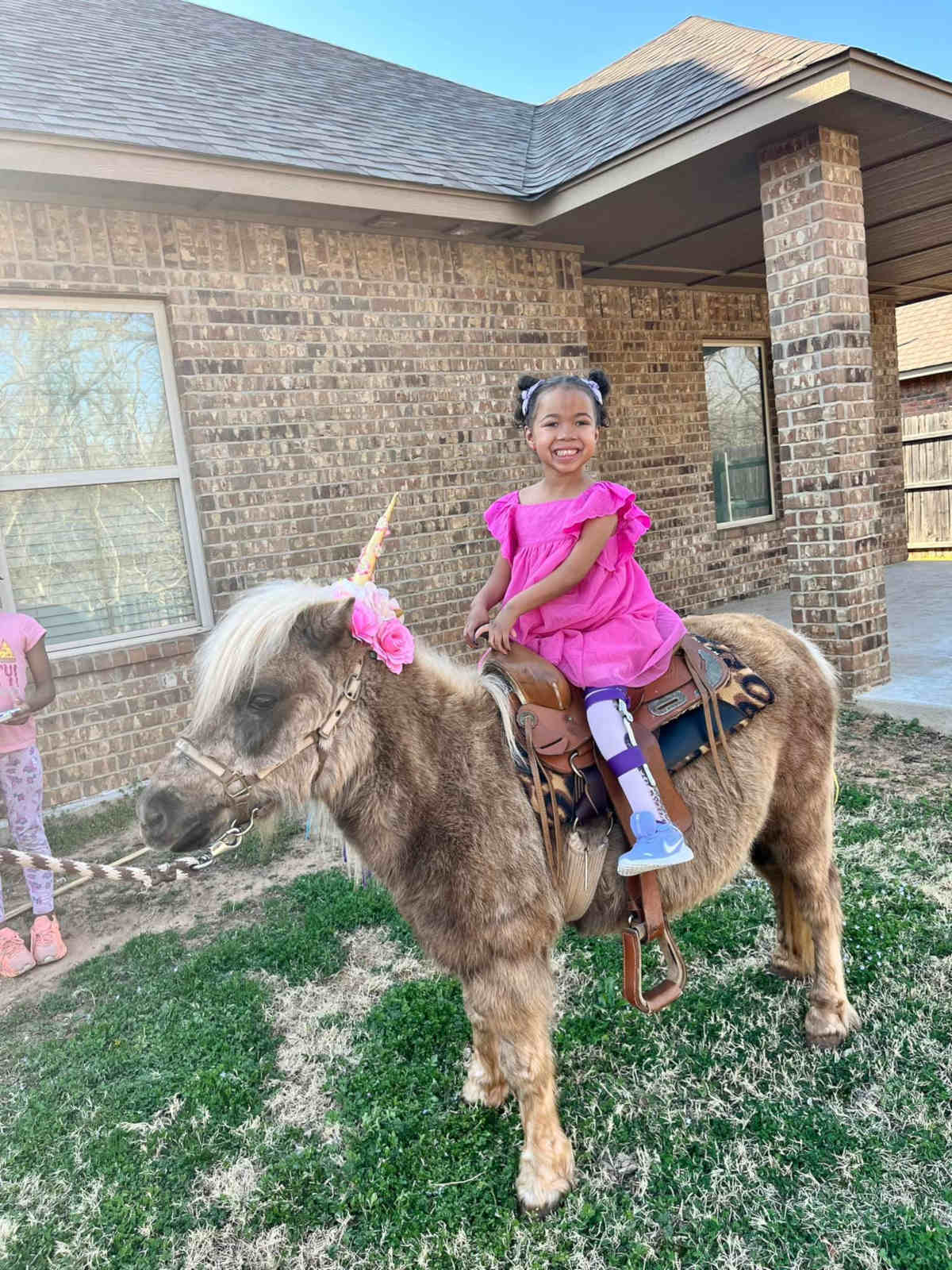 Brielle in pink dress, riding pony