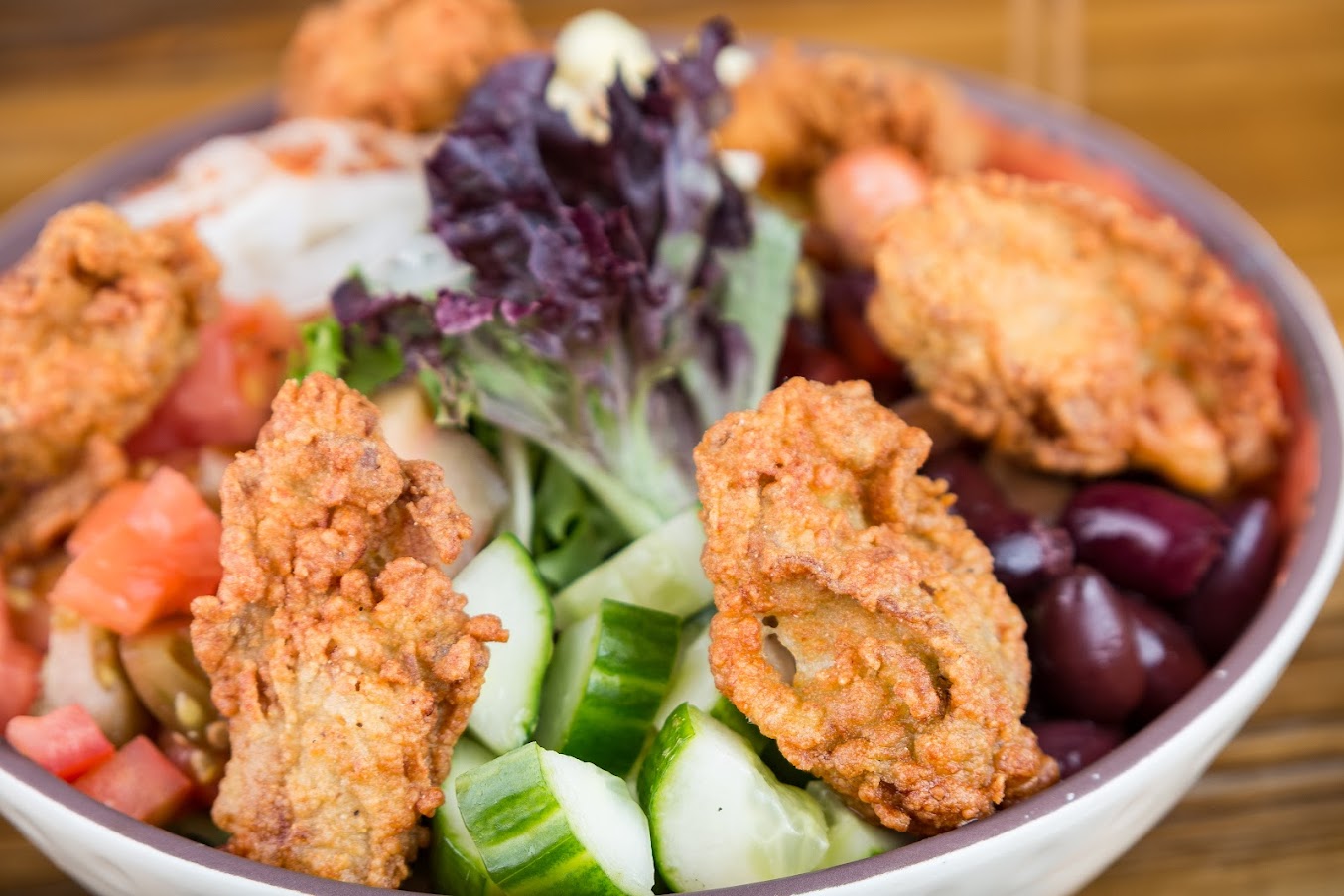 Fried oyster salad, with tomato, cucumber, lettuce, kalamata olives and onion