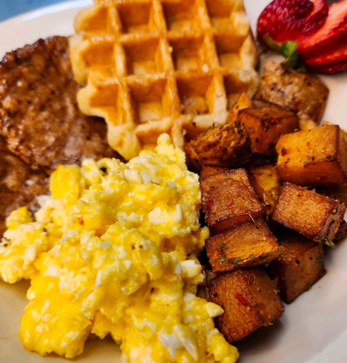 eggs, crispy potatoes, and golden waffles, perfect for a hearty breakfast.