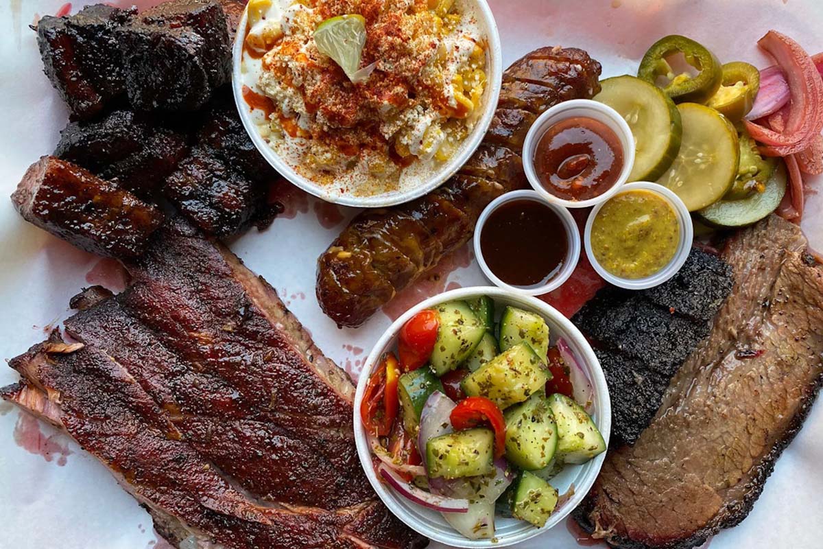 Assorted BBQ meats served with sides and condiments