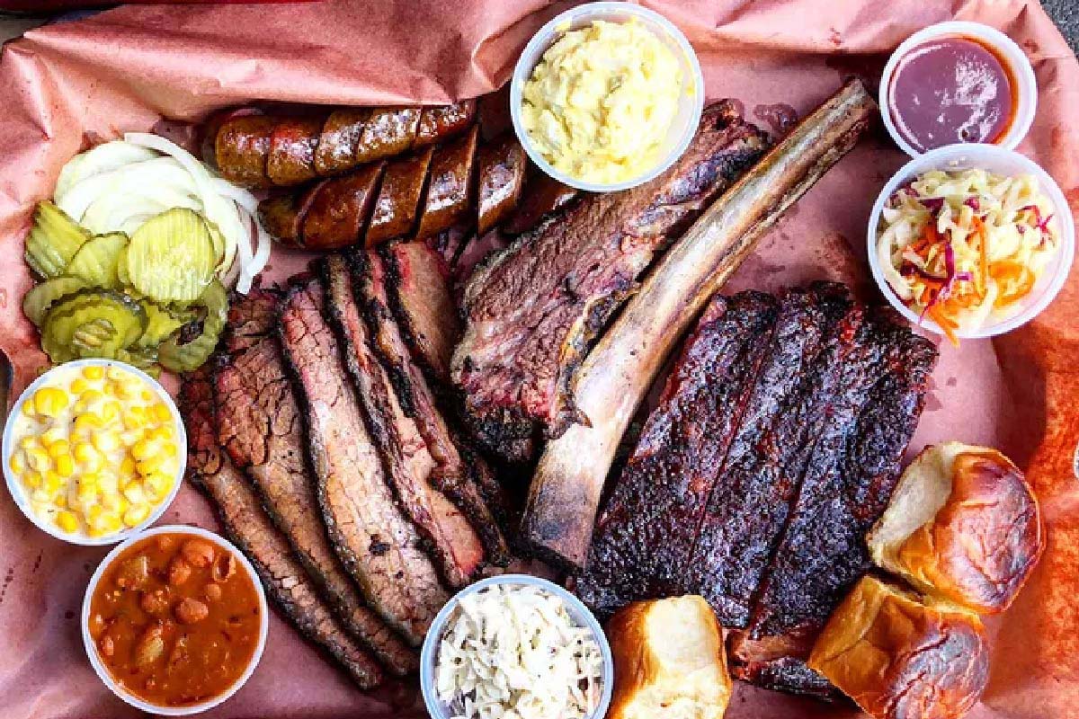 Top view of a platter with different BBQ meats and side dishes