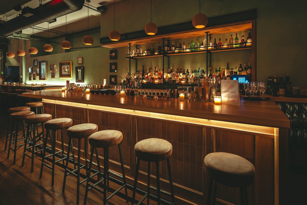 A cozy bar with wooden stools and flickering candles, creating a warm and inviting ambiance.