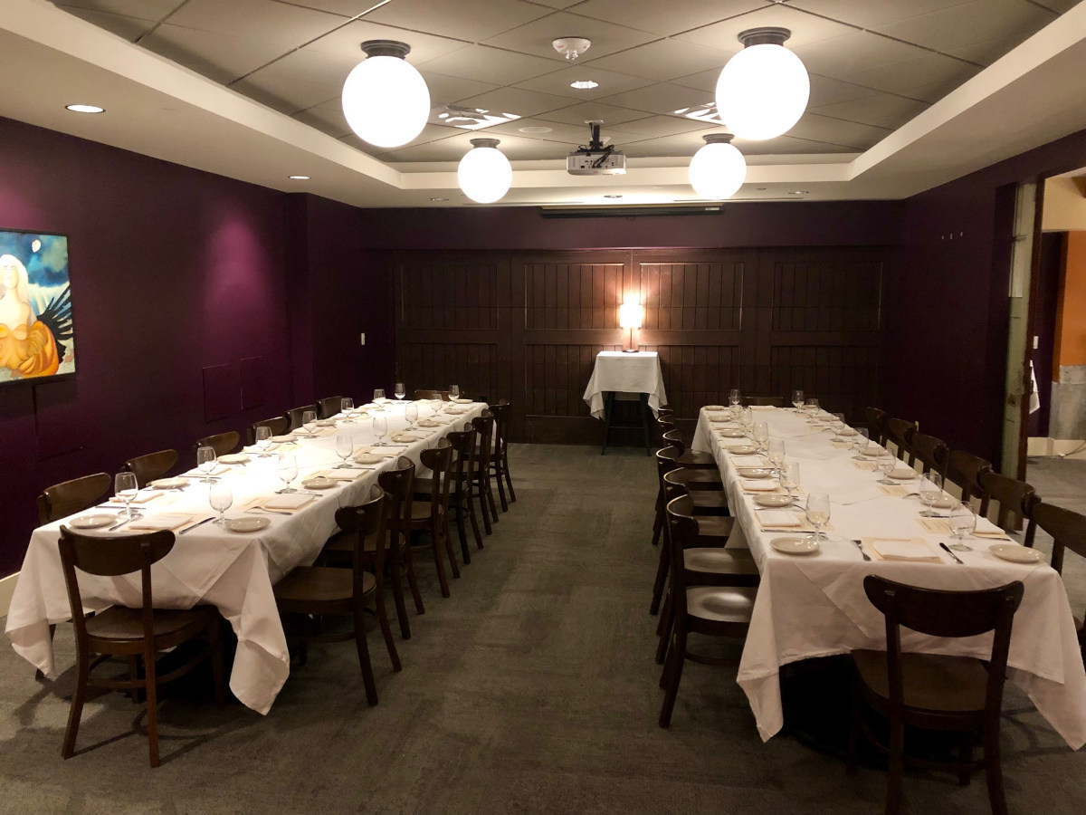 a dining room with purple walls and white tablecloths.